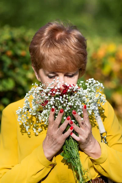 Mujer mayor con un ramo de flores . —  Fotos de Stock