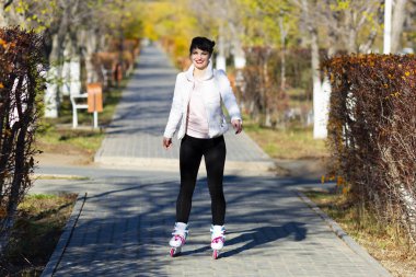 Kız kaymayı öğreniyor, güneşli bir günde.