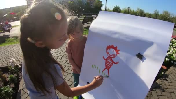 Uma Menina Desenha Seu Irmão Como Modelo Menino Apresenta Como — Vídeo de Stock