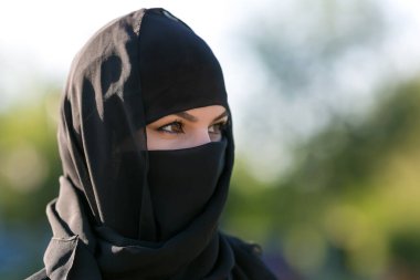 Siyah elbiseli Müslüman bir kadının portresi. Ulusal giyinmiş İslami kadın, yakın plan siyah elbiseler.