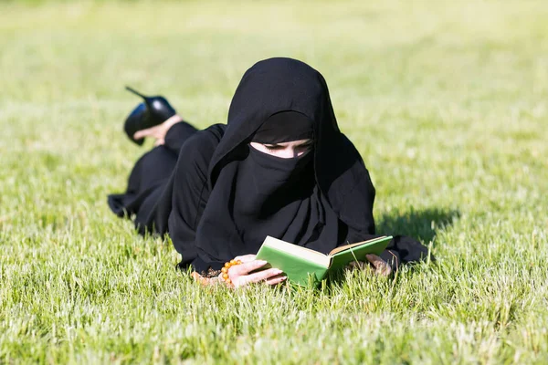 Islamitische Vrouw Leest Een Boek Een Grasveld Een Park Moslim — Stockfoto