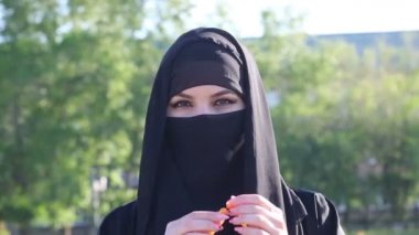 Ulusal kadın kıyafetleri içindeki İslami kadın ellerinde dini tespih tutuyor. Müslüman kadın tespih puanlarıyla ayakta duruyor. 