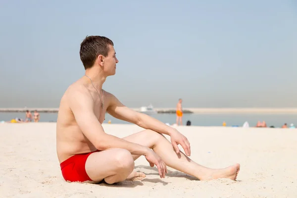 Descansar Homem Caucasiano Sentado Praia Turista Anos Calções Banho Vermelhos — Fotografia de Stock