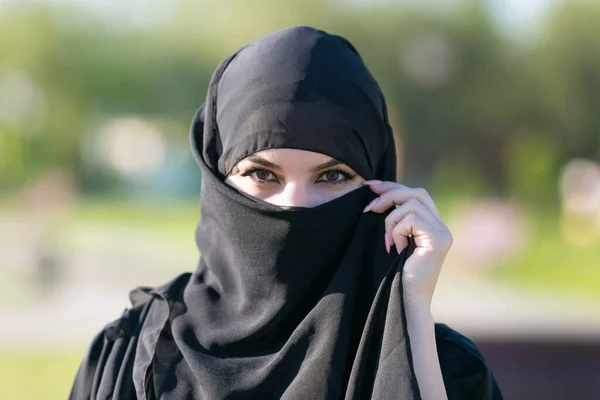 Sokakta giyinmiş, doğulu bir kadın. Orta Doğu 'dan Avrupa ülkesine göç eden bir kadının büyük bir portresi.