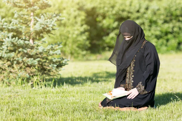 通りに東の女性の朝の祈り イスラム教徒のアラビア語の女の子祈る神に座って草で公園 — ストック写真