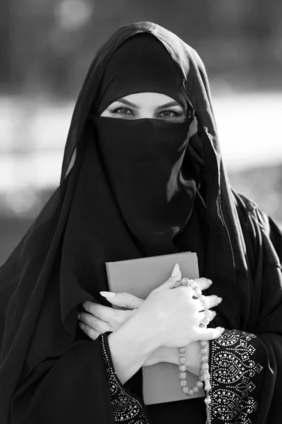 一位穆斯林妇女站在那里 手里拿着古兰经 手里拿着一本卡兰的圣书 祈祷着 黑白图像 — 图库照片