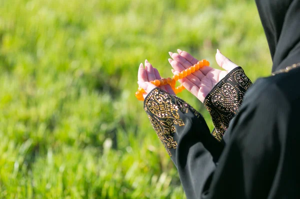 阿拉伯女孩坐在公园的草地上祈祷 阿拉伯女孩坐在公园的草地上祈祷 手靠紧 — 图库照片