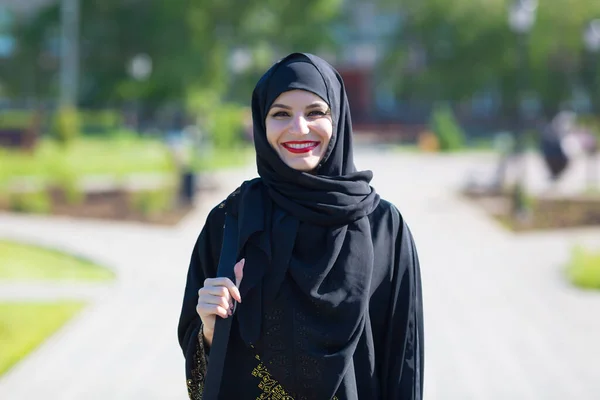 A happy Muslim woman in oriental clothes walks. A happy Muslim woman in oriental clothes walks beautifully among the trees