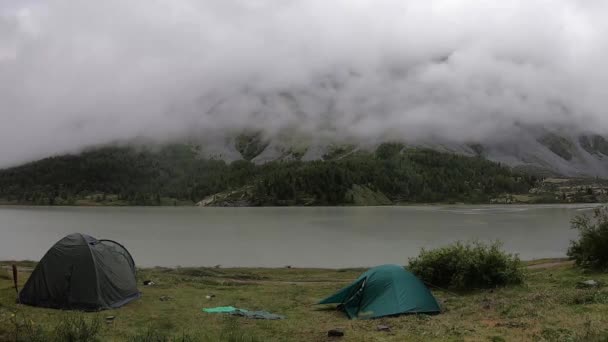 湖面附近的一个旅游帐篷上罩着厚厚的白云 下着雨 — 图库视频影像