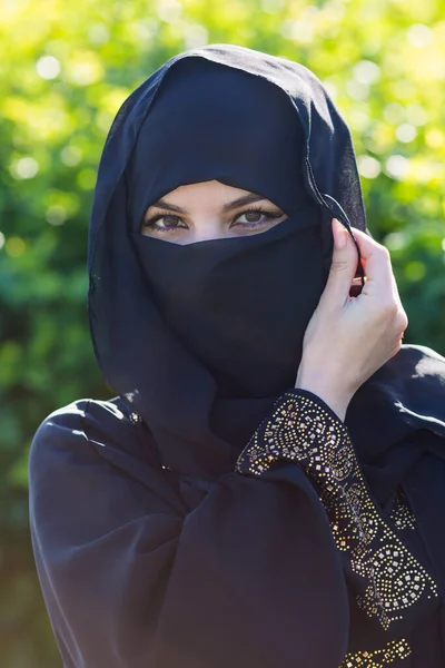 Een Migrantenvrouw Uit Het Oosten Zwarte Kleren Staat Tegen Heldergroene — Stockfoto