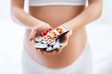 Hamilelik vitaminleri ve ilaçlar. Hamile kadının hap el göbek tutan kapatın. Yüksek çözünürlük