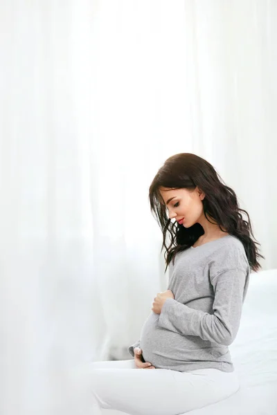 Kobiety Ciąży Piękny Szczęśliwy Kobieta Ciąży Brzuchem Pomieszczeniu Siedzi Łóżku — Zdjęcie stockowe