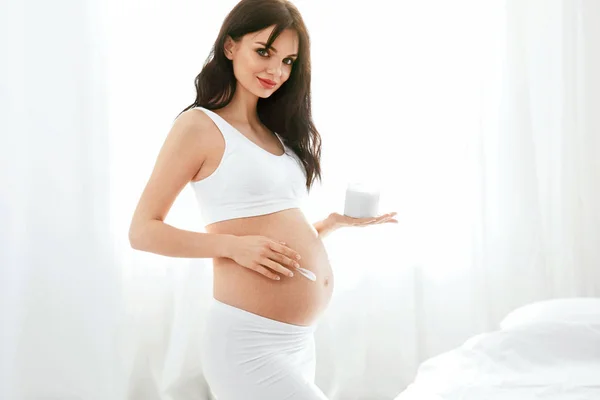 妊娠中のスキンケア 美しい妊娠中の女性は 家でお腹にクリームを適用します 高分解能 — ストック写真