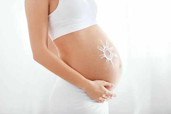 Baby Belly Skin Care. Pregnant Woman's Tummy With Cream Sun On Skin. High Resolution