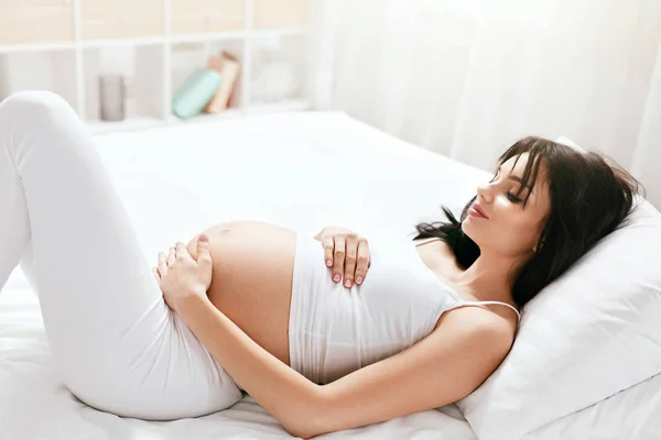 怀孕的女孩 腹部躺在床上 美丽的女人在白色的内部休息 高分辨率 — 图库照片