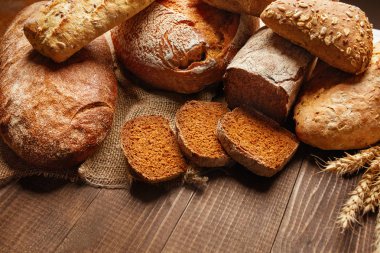 Ekmek. Ekmek ahşap arka plan üzerinde. Ahşap masa üzerinde pişmiş gıda çeşitli closeup. Yüksek çözünürlük