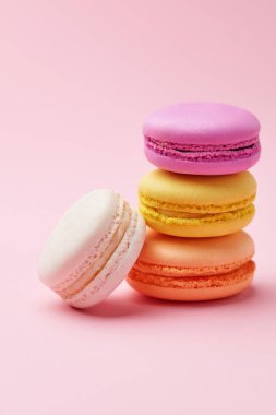 Macarons. Pembe bir arka plan üzerinde renkli Fransızca Macaroons. Tatlı veya çerezleri natürmort. Yüksek çözünürlük