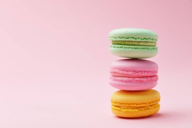 Macarons. Pembe bir arka plan üzerinde renkli Fransızca Macaroons. Tatlı veya çerezleri natürmort. Yüksek çözünürlük