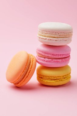 Macarons. Pembe bir arka plan üzerinde renkli Fransızca Macaroons. Tatlı veya çerezleri natürmort. Yüksek çözünürlük