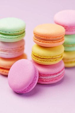 Tatlılar. Macarons yakından. Pastel pembe bir arka plan üzerinde renkli tatlı tatlı. Yüksek çözünürlük