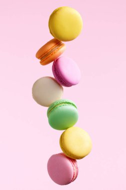 Macaron tatlı. Renkli Macaroons uçan. Fransız tatlı pembe arka plan düşen hareket. Yüksek çözünürlük