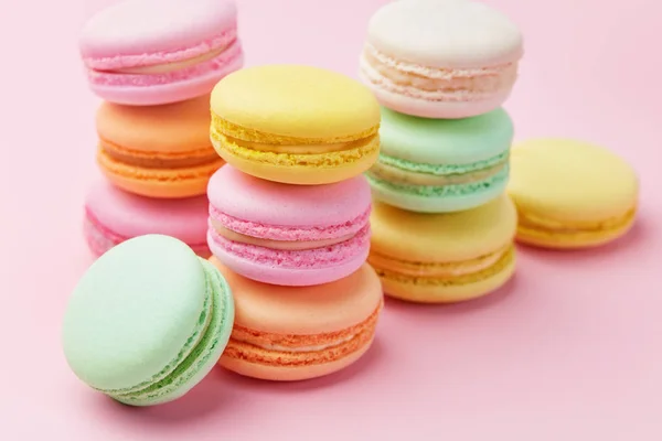 デザート カラフルなマカロンをクローズ アップ ピンクの背景にさまざまな色のマカロン 高分解能 — ストック写真
