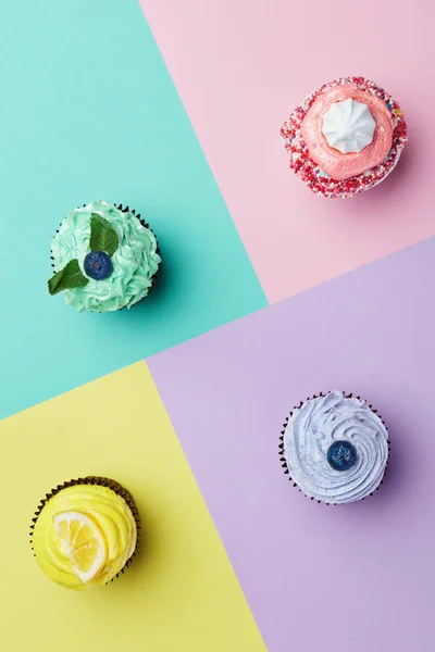 Cupcakes Desserts On Colorful Background. Cakes With Different Colors Cream And Toppings. High Resolution