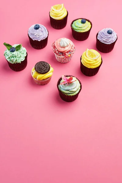 Colorful Cupcakes On Pink Background. Cake Desserts With Cream And Different Toppings. High Resolution