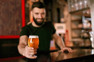 Zanaat bira. Barda, barmen de Counter Bar bira ile cam tutan adam. Yüksek çözünürlük.