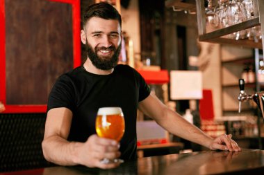 Zanaat bira. Barda, barmen de Counter Bar bira ile cam tutan adam. Yüksek çözünürlük.