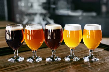 Ahşap masa portre bira gözlük. Pub Bar soğuk taze bira farklı türleri. Yüksek çözünürlük.