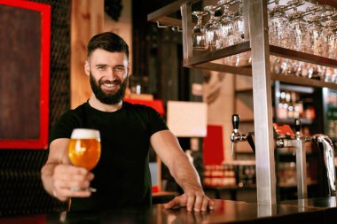 Zanaat bira. Barda, barmen de Counter Bar bira ile cam tutan adam. Yüksek çözünürlük.