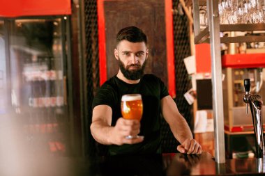 Zanaat bira. Barda, barmen de Counter Bar bira ile cam tutan adam. Yüksek çözünürlük.