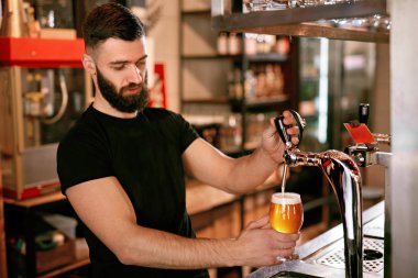 Barmen, Pub Bar çalışma. Fıçı bira bardağında dökme yakışıklı adam. Yüksek çözünürlük.