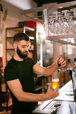 Barmen, Pub Bar çalışma. Fıçı bira bardağında dökme yakışıklı adam. Yüksek çözünürlük.