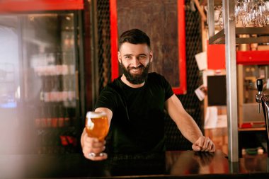 Zanaat bira. Barda, barmen de Counter Bar bira ile cam tutan adam. Yüksek çözünürlük.
