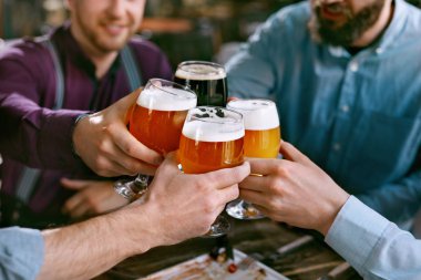 Bira içiyor. Arkadaşlar bardak bira masada Pub Bar gıda ile yükselterek. Yüksek çözünürlük.