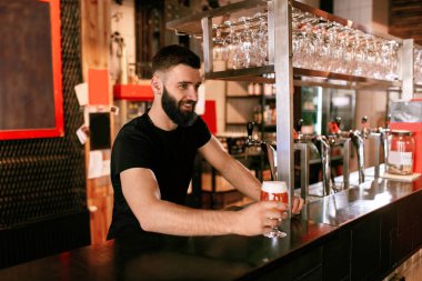 Barmen ile fıçı bira cam çubuk. Gülümseyen adam barda çalışıyor. Yüksek çözünürlük.