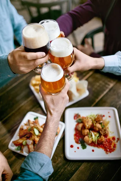 Beber Cerveja Amigos Levantar Copos Cerveja Mesa Com Comida Bar — Fotografia de Stock