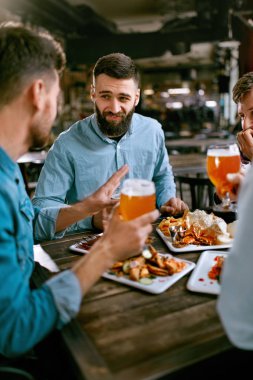Arkadaşlar bira içme ve yemek yeme Pub restoranda akşam yemeği. Yüksek çözünürlük.