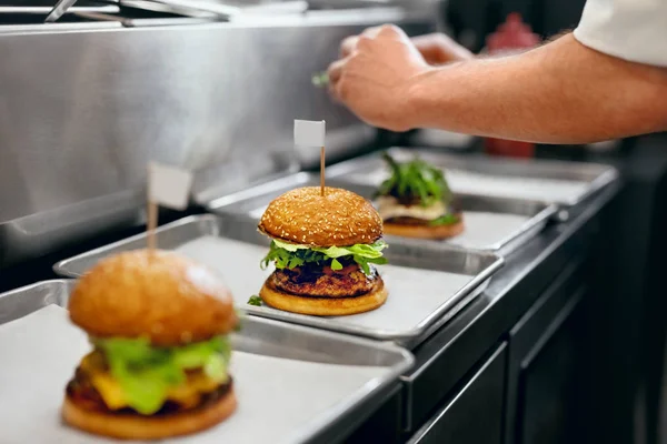 Burger Restaurant. Closeup Chef Cooking Burgers In Kitchen. High Resolution.