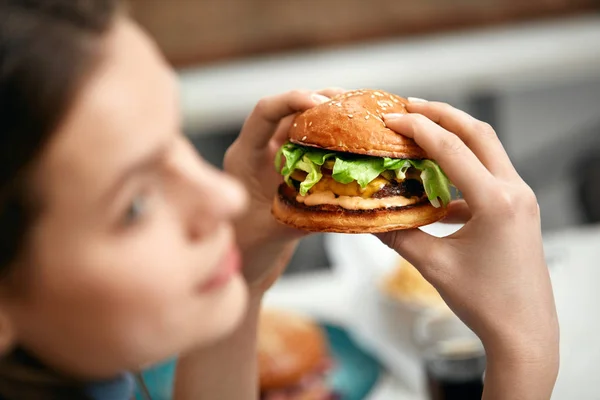 Eating Burger. Woman Holding Hamburger In Hands At Fast Food Restaurant. High Resolution.