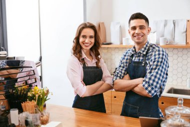 Barista ve Cafe, kahve dükkanında Counter Bar yakınındaki ayakta önlük mutlu işçi çalışan garson. Yüksek çözünürlük.