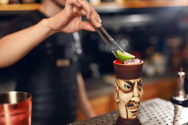 Kokteyl hazırlama. Barmen tiki kireç içkiyle dekorasyon Bar, kokteyl, yapma. Yüksek çözünürlük.