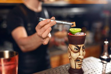Kokteyl hazırlama. Barmen tiki içki kireç ve küp şeker ile dekorasyon Bar, kokteyl, yapma. Yüksek çözünürlük.