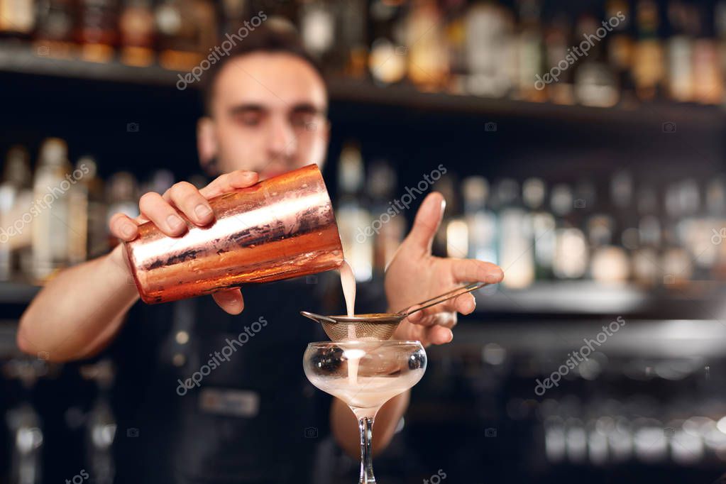 Bar de cócteles. Cantinero haciendo cócteles, sirviendo bebida en un