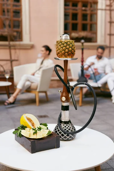 Shisha With Fruits On Table In Hookah Bar Closeup. People Smoking And Relaxing On Background. High Resolution