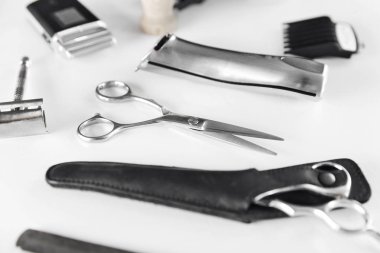 Erkek bakım araçları. Kuaför Ekipmanları ve malzemeleri Beyaz masada. Closeup makas ve tıraş düzeltici ve bıçaklar. Yüksek çözünürlük