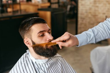Sakal kuaför dükkanında kesti. Saç kesimi yapıyor makasla kesme adamın sakalı berber. Yüksek çözünürlük