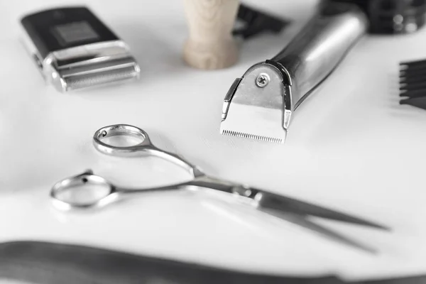 Men\'s Grooming Tools. Barber Equipment And Supplies On White Table. Closeup Of Scissors And Shaving Trimmer And Blades. High Resolution